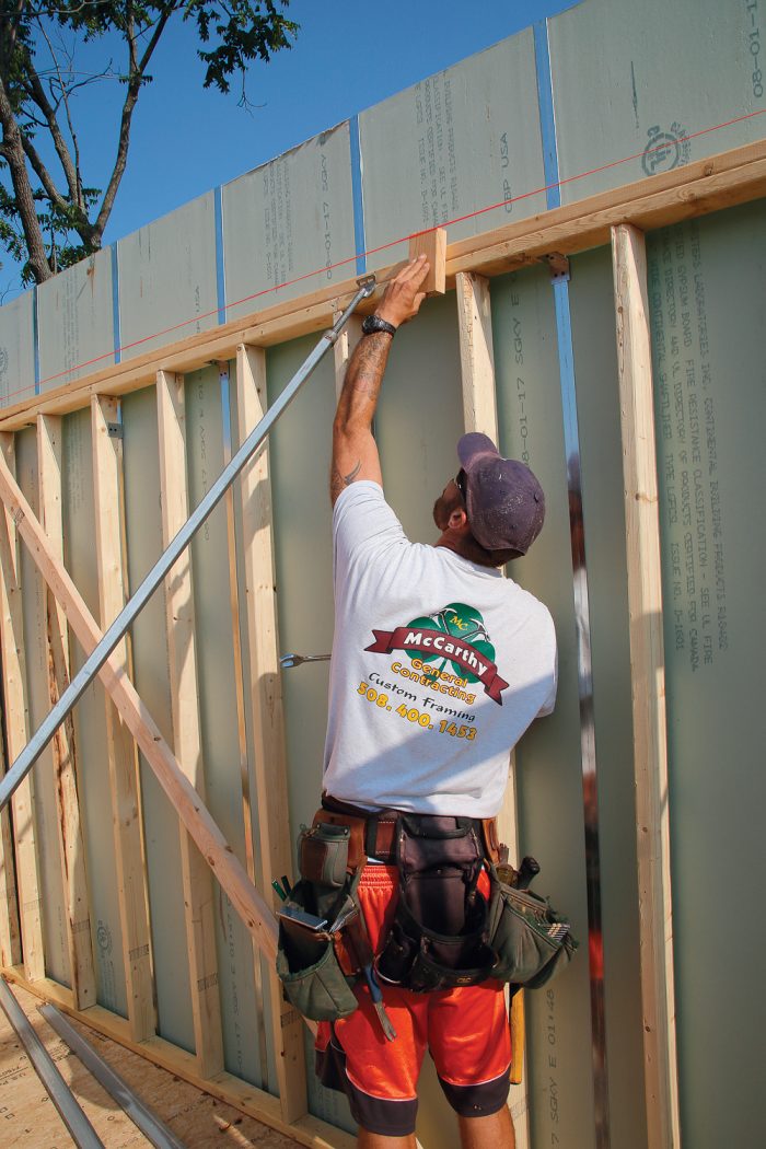 Starting with the longest wall, check the distance from the string near the center brace first, and then check the distance to the string close to the braces on either side, working toward the corners.