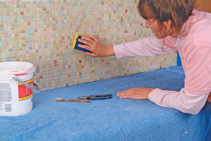 Clean glass tile with the soft foam side of a sponge